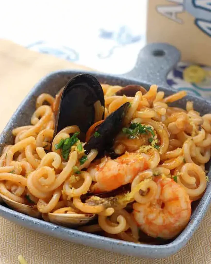 Fotografia del piatto di Capricciose risottate allo scoglio e limone su una tavola apparecchiata